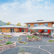 Wohnmobilstellplatz_Ölmühle Solling.jpg Großer, moderner Wohnmobilstellplatz mit hellen Gebäuden, gepflegten Gärten und umliegender Landschaft.