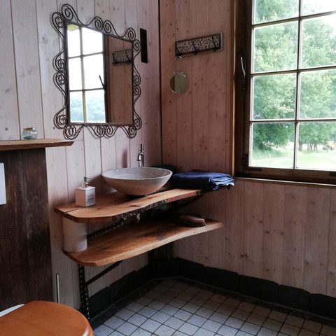 Badezimmer Modernes Badezimmer mit rustikalem Holzdesign, Waschbecken auf Holzplatte, und großem Fenster mit Landschaftsblick.