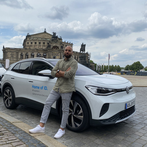Racing reporter in Dresden Mann vor einem Elektroauto an der SemperoperMan in front of an electric car at the Semperoper opera house