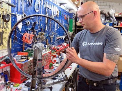 Henze_0008.jpg Manuel Schumann in der Werkstatt, arbeitet an einem Rad
