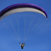 Gleitschirm-Flieger_Hotel Rehkitz.jpg Gleitschirmflieger schwebt am klaren blauen Himmel, der violette Schirm öffnet sich majestätisch über ihm.