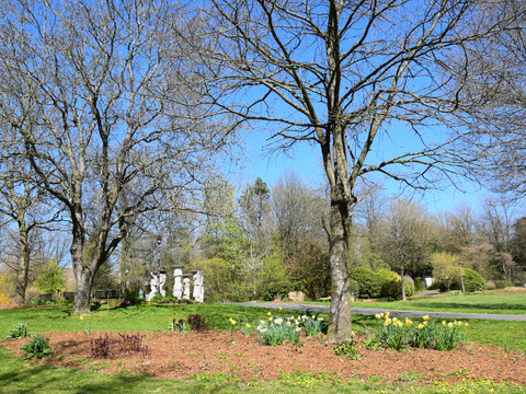 Kurpark in Nümbrecht  <p>Frühlingsgarten mit blühenden Narzissen, Skulpturen im Hintergrund und klarer, blauer Himmel.</p>