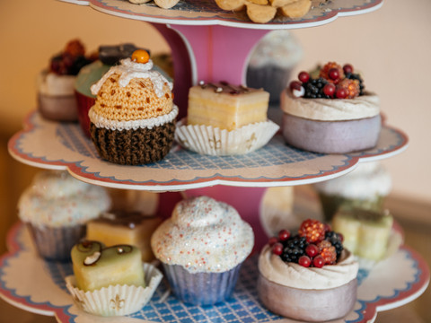 Das Bild zeigt eine Étagère mit bunten Cupcakes und Pralinen der Bäckerei und Konditorei Göbecke, Süßwaren, Konditorei