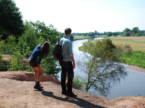 Zwei Wanderer stehen am Steilhang des Roten Ufers und schauen auf den Flusslauf der Mulde, Wandern, Aktiv, Natur