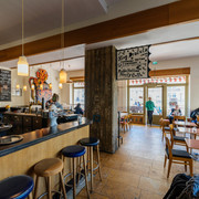 Café Cantona - Gastronomie Leipzig Blick in den gemütlichen Gastraum des Café Cantona mit Holzbar und breiter Fensterfront