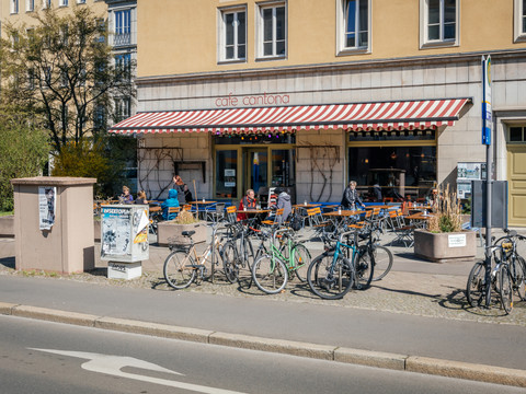 Blick auf die Fassade des Café Cantona an der Windmühlenstraße mit Freisitz und vielen Fahrrädern, gastronomie, kulinarik