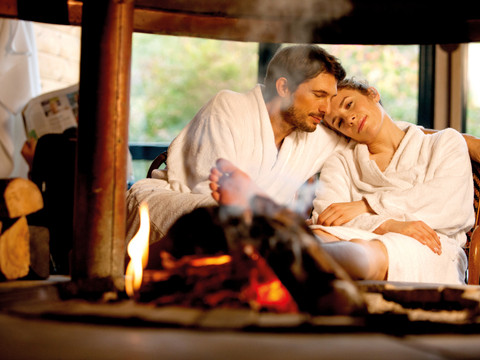 Wellness Sachsen-Therme - Volný čas v Lipsku Pár v županech před krbem v hotelu Sachsen-Therme Leipzig.