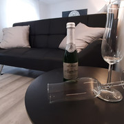 Sitzecke.jpg Sofa mit Beistelltischchen und SektgläsernSofa with side table and champagne glasses