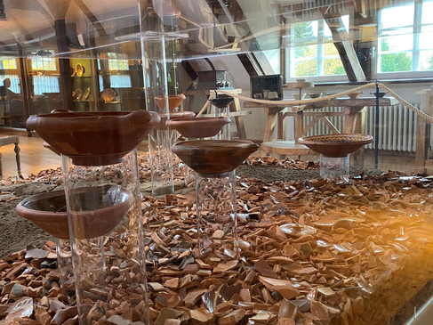 Vitrine mit römischen Tongefäßen und Fragmenten in einem Archäologiemuseum.