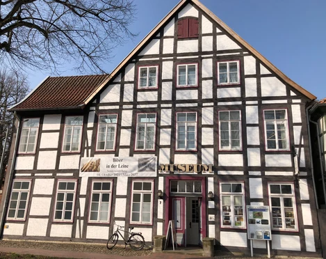 Museum zur Stadtgeschichte Fachwerkgebäude mit weißer Fassade und braunen Holzbalken, Eingangstür mit Museumsaufschrift.
