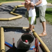 Vater mit Sohn beim Minigolf
