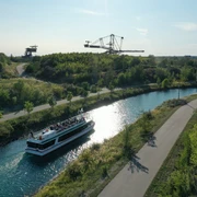 Personenschifffahrt nahe des Bergbau-Technik-Parks - Leipziger Neuseenland Das Personenschiff fährt durch eine Schleuse Richtung Störmthaler See am Bergbau-Technik-Park bei sonnigem Wetter entlang, Leipziger Neuseenland, Industriekultur, Ausflug, Leipzig Region