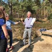 Wolfgang Koltermann  Wolfgang Koltermann spricht leidenschaftlich in einem sonnigen Kiefernwald zu Zuhörern.