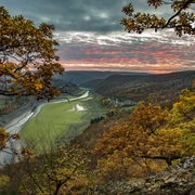 Herbstlicher Sonnenuntergang von einem knorrigen Eichenhang