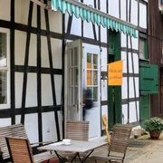 Biohof Hofcafe auf Hof zur Hellen im Windrather Tal be Velbert Traditionelles Fachwerkhaus mit Außenterrasse und geöffnetem Hofcafé im Windrather Tal bei Velbert.