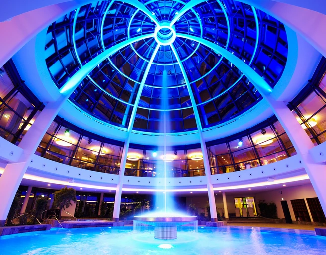 Kuppel der carpesol SPA Therme in Bad Rothenfelde Kuppelbeleuchtetes Badeparadies mit blauem Licht und einem zentralen Wasserbrunnen.