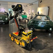 Polizeimuseum Niedersachsen Ein Innenraum des Polizeimuseums Niedersachsen mit historischen Polizeiautos und einem Roboter.