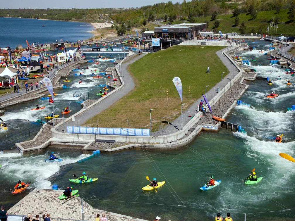 Paddelfestival im Kanupark Markkleeberg - Wassersport in Leipzig und Region Blick auf die Wildwasseranlage im Kanupark Markkleeberg zum Paddelfestival mit zahlreichen Sportbegeisterten in Kanus auf dem Wasser, Wassersport, Freizeitaktivität