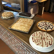 Kloencafe1.JPG Eine Auswahl an köstlichen Kuchen, liebevoll auf einem rustikalen Tresen im Café arrangiert.
