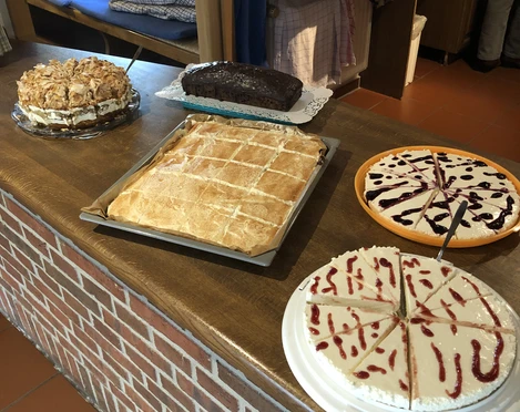 Kloencafe1.JPG Eine Auswahl an köstlichen Kuchen, liebevoll auf einem rustikalen Tresen im Café arrangiert.