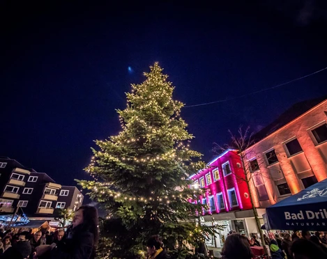 Adventsmarkt in Bad Driburg mit beleuchtetem Tannenbaum in der Mitte.