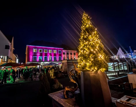 Adventsmarkt in Bad Driburg mit beleuchtetem Tannenbaum in der Mitte.