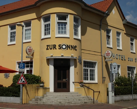 Hotel zur Sonne Gelbes Gebäude des Hotel zur Sonne mit roten Dächern und seitlichen Treppen.