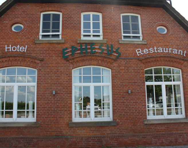 Hotel und Restaurant Ephesus am Weserwehr Historisches Backsteingebäude mit großen, weißen Fenstern, Schriftzug "Ephesus", am Weserwehr.