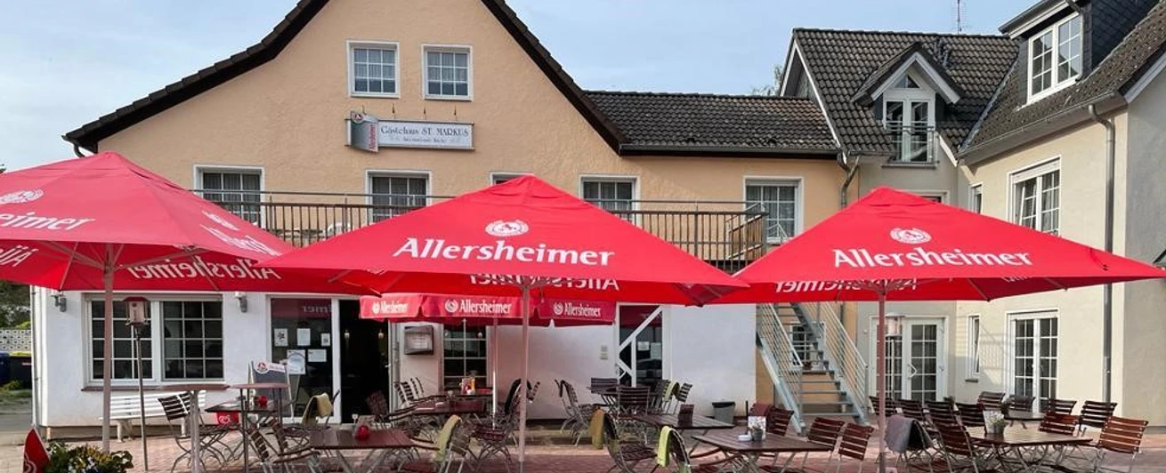 st-markus-restaurent-geastezimmer.jpg Terrasse des Gästehauses mit Tischen und Sonnenschirmen