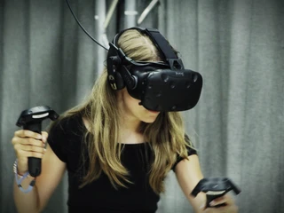 7th Space VR Langenfeld Ein Mädchen taucht mit VR-Headset und Controllern in eine virtuelle Welt ein, voller Konzentration.