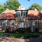 Fikensolt4.JPG Ein historische Backsteinherrenhaus mit symmetrischem Rotdach und gepflegtem Garten.