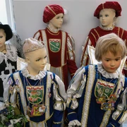 Rheinisches Karnevalsmuseum Fünf Schaufensterpuppen präsentieren mittelalterliche Karnevalskostüme mit aufwendiger Verzierung.