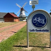 Lufttankstelle Behlmer Mühle Lufttankstelle für Fahrräder vor der historischen Behlmer Mühle mit weißen Flügeln und rotem Dach.