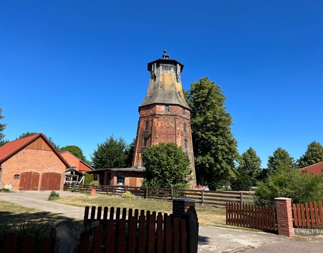 Mühle Hassel Historische Windmühle Hassel aus rotem Backstein, umgeben von Bäumen und blauen Himmel, in ländlicher Umgebung.