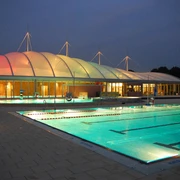 Allwetterbad Lintorf in Ratingen Beleuchtetes Allwetterbad Lintorf in Ratingen, Außenansicht bei Abenddämmerung mit Pool und Pavillon.