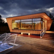 Mona Mare in Monheim am Rhein Modernes Gebäude mit großen Glasfronten, umgeben von beleuchteten Treppen und Gehwegplatten.