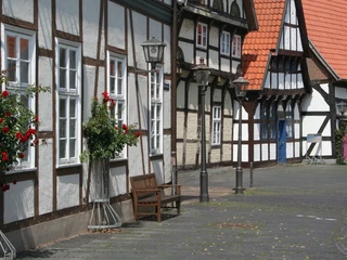 Altstadt Nienburg Fachwerkhäuser in Nienburg mit roten Dachziegeln, geschmückt mit Blumen und historischen Straßenlaternen.
