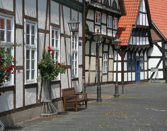 Altstadt Nienburg Fachwerkhäuser in Nienburg mit roten Dachziegeln, geschmückt mit Blumen und historischen Straßenlaternen.