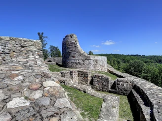 Falkenburg Ruinen der Falkenburg mit erhaltenem Turmstumpf im Hintergrund, umgeben von grünen Wäldern.