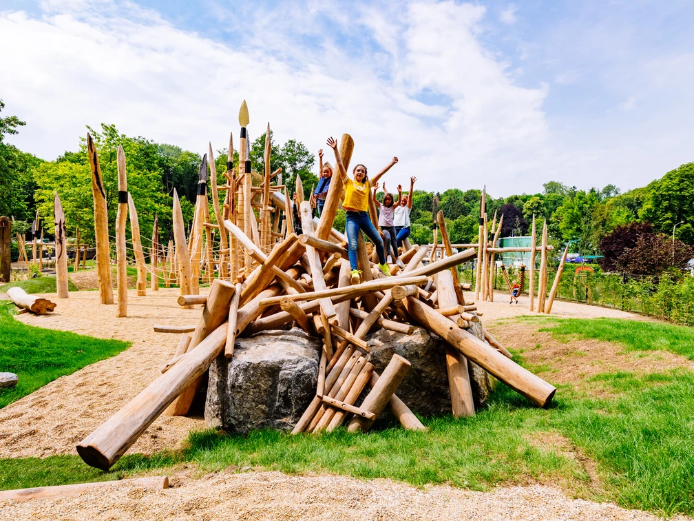 Steinzeitspielplatz am Neanderthal Museum in Mettmann Kinder spielen auf einem aus Holzstämmen gestalteten Abenteuer-Spielgerät im Freien.