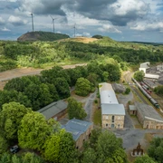MIK am Piesberg in Osnabrück Industriegelände am grünen Piesberg, Osnabrück, mit Windkraftanlagen und historischer Architektur.