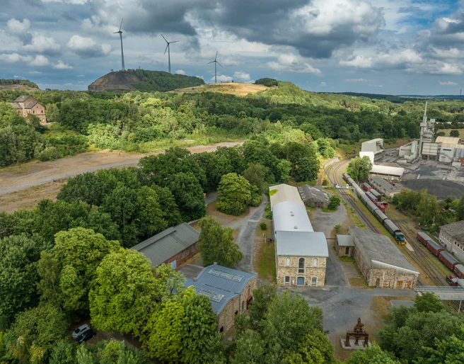 MIK am Piesberg in Osnabrück Industriegelände am grünen Piesberg, Osnabrück, mit Windkraftanlagen und historischer Architektur.