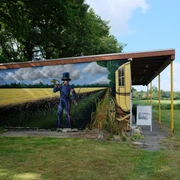 Postmuseum Bokel Das Gebäude des Postmuseums in Bokel mit einer großen Wandmalerei eines Postboten und einer Kutsche.