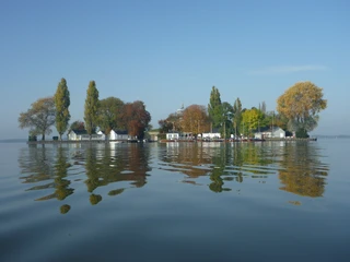 Insel Wilhelmstein Im klaren Wasser spiegeln sich herbstliche Bäume und historische Gebäude der Insel Wilhelmstein.
