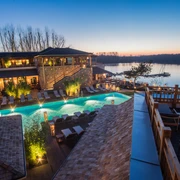 Vabali Spa in Hilden Ein modernes Spa mit Außenpool, umgeben von üppigem Grün und entspannender Flusslandschaft in der Abenddämmerung.
