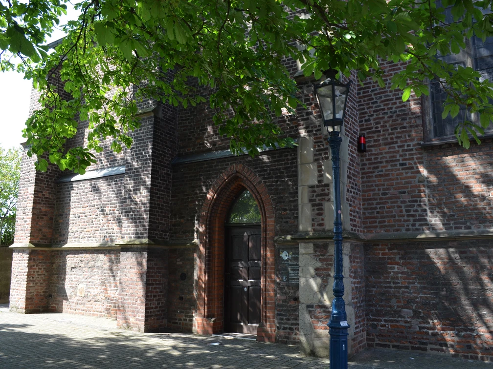 Marienkapelle in Monheim am Rhein Backsteinbau der Marienkapelle in Monheim am Rhein mit Spitzbogenportal und umgebender Straßenlaterne.