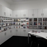 Tourist-Information Ratingen Reiseführer und Broschüren in einem Informationszentrum mit weißen Schränken und einem Tisch.