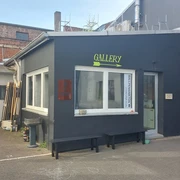 Arty Farty Ein moderner Galerieeingang mit dezenten Farben und klaren Linien in einem urbanen Umfeld.A modern gallery entrance with subtle colors and clean lines in an urban environment.