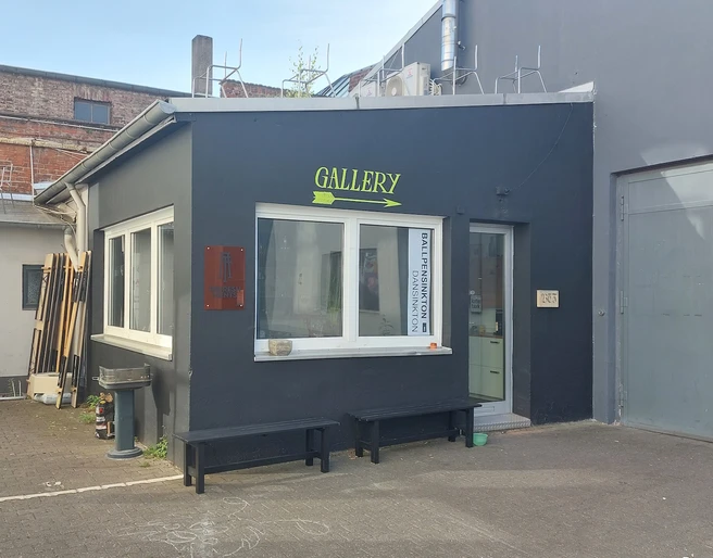 Arty Farty Ein moderner Galerieeingang mit dezenten Farben und klaren Linien in einem urbanen Umfeld.A modern gallery entrance with subtle colors and clean lines in an urban environment.