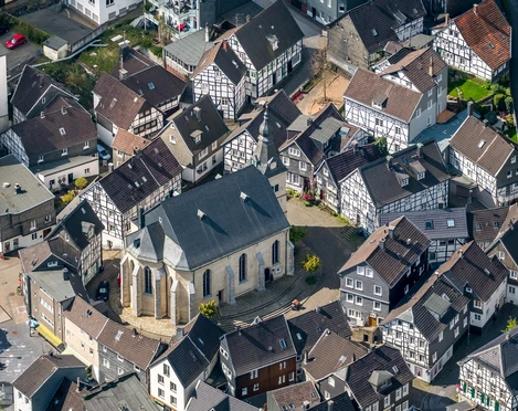 Velbert-Neviges Luftaufnahme von Fachwerkhäusern um die imposante Vorstadtkirche Velbert-Neviges bei Sonnenschein.